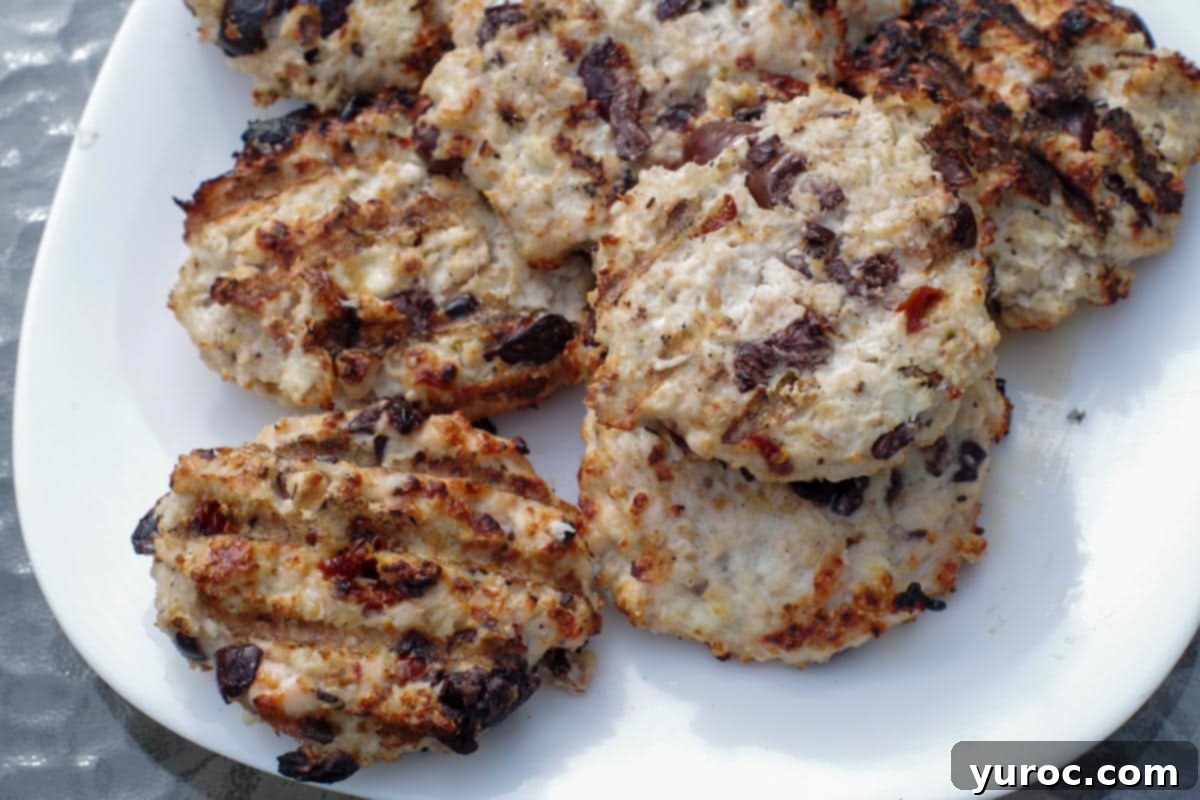 grilled Greek chicken burgers on white plate