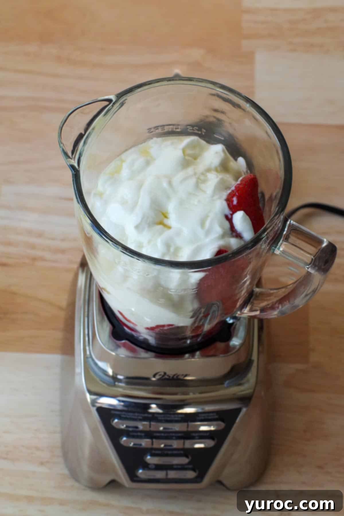 Fresh hulled and chopped strawberries, Greek yogurt, agave, and coconut extract are ready to be blended for strawberry yogurt popsicles.