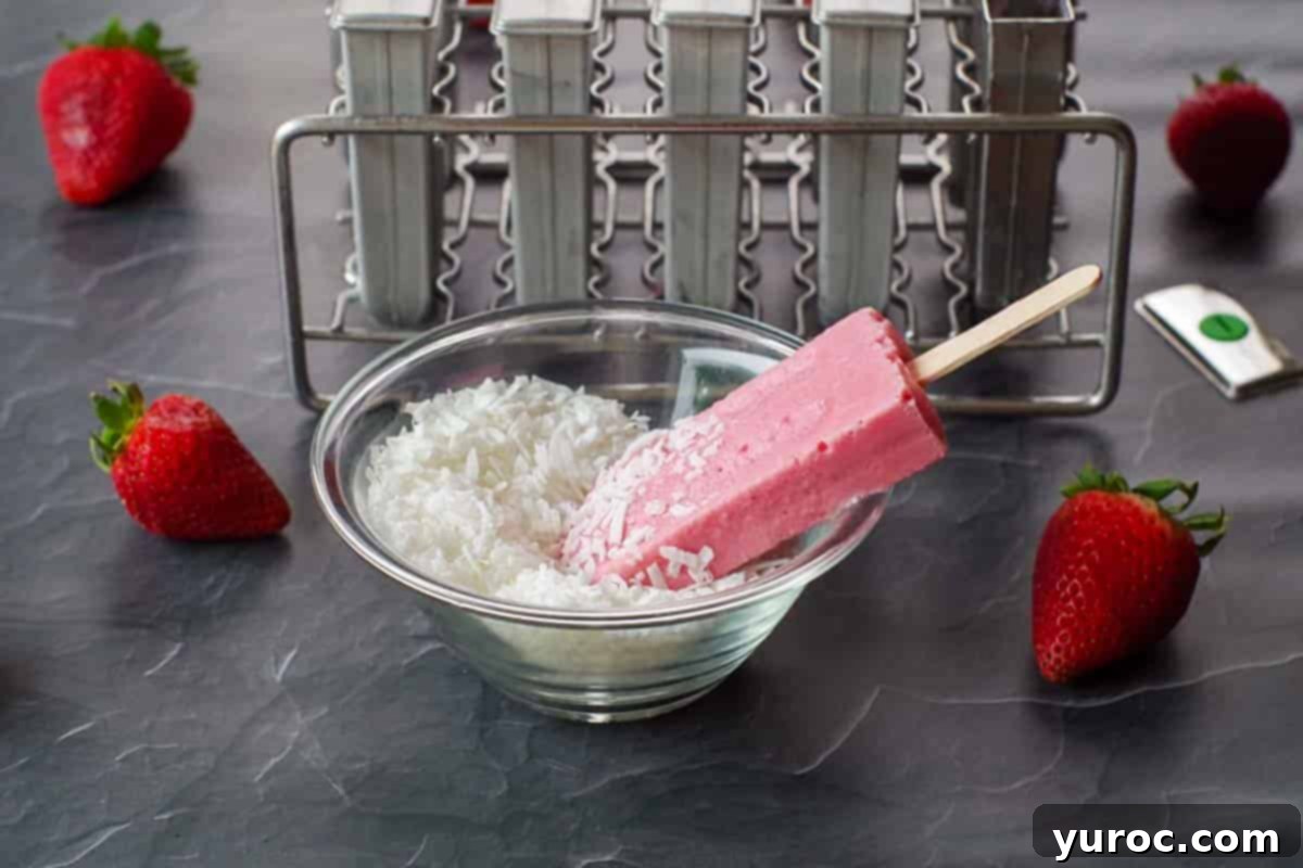 A delicious strawberry Greek yogurt popsicle is presented in a small bowl, adorned with a sprinkle of shredded coconut.