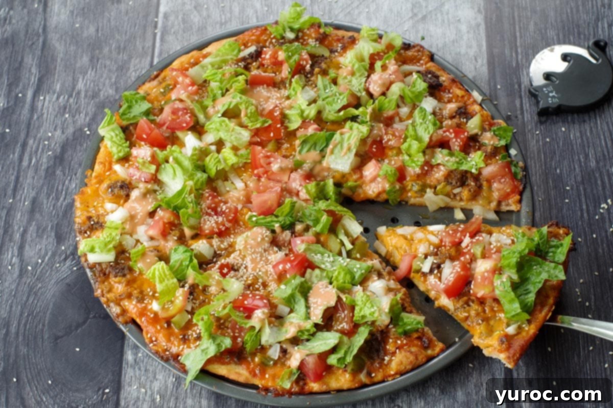 whole big mac pizza with piece being lifted out