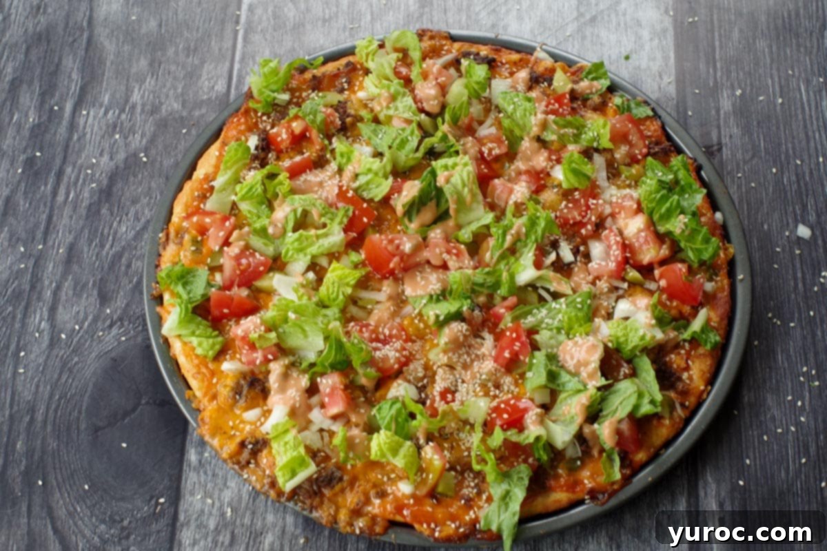 lettuce tomatoes, onions, pickles and sesame seeds added to big mac pizza