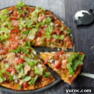whole big mac pizza with piece being lifted out