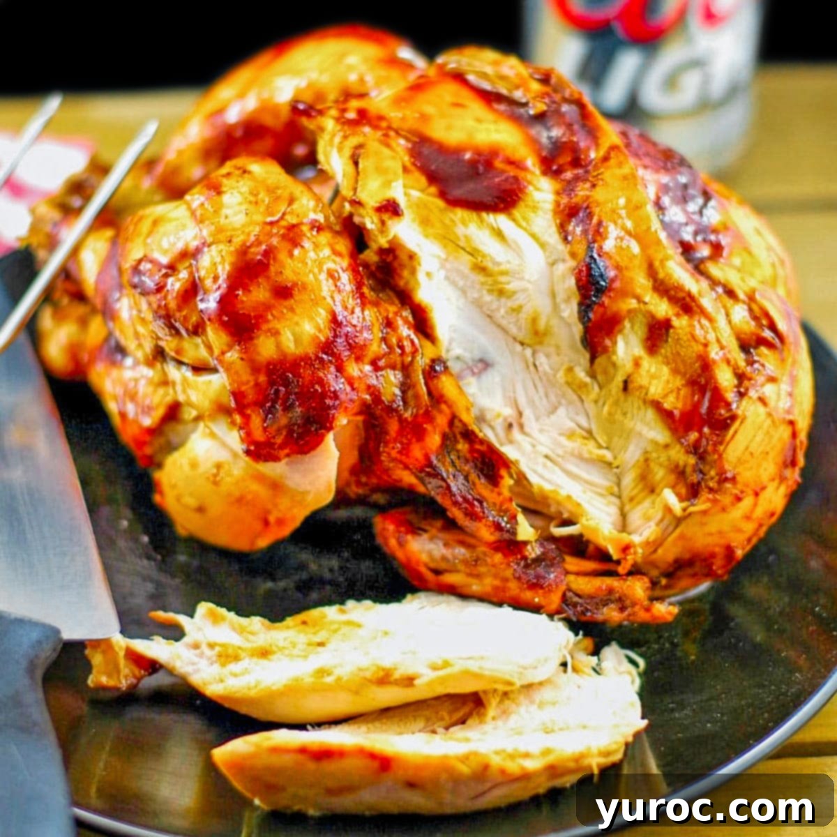 Effortless Butter Tart Dream Ice Cream 15 Slices of juicy Beer Can Chicken on a black plate with a knife, and a beer can in the background, showing a perfect meal pairing for butter tart ice cream.