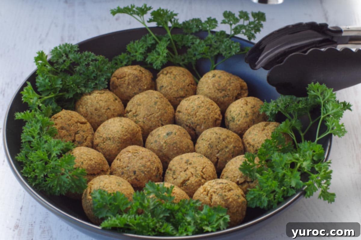 Crispy Air Fryer Falafel from Mix 10 cooked air fryer falafel balls in a black bowl with parsley