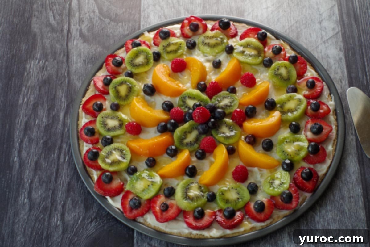 Vibrant Fruit Pizza with Sweet Glaze 15 The fully assembled fruit pizza, with a generous drizzle of the shiny orange glaze over the colorful fresh fruit, enhancing its appeal.