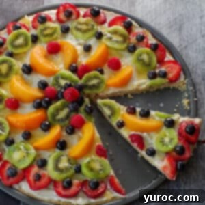 Vibrant Fruit Pizza with Sweet Glaze 19 A vibrant fruit pizza slice being carefully lifted, highlighting its creamy topping, colorful fresh fruit, and buttery shortbread crust.