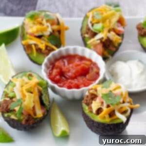A white tray filled with vibrant avocado tacos, garnished with a dollop of fresh salsa and a swirl of sour cream in the center, flanked by bright lime wedges