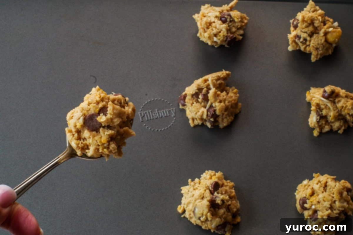 Grab-and-Go Cereal Cookies for School 9 teaspoon with cookie dough over baking sheet with cookie dough