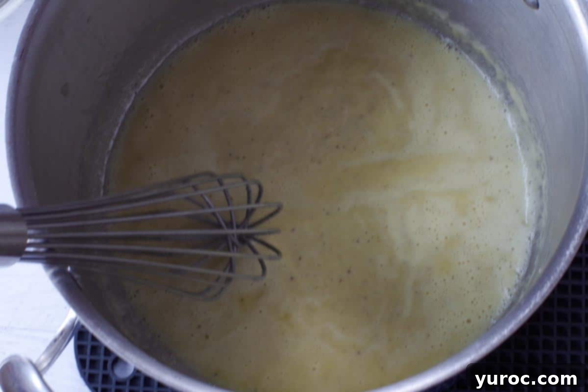 Silky Light Chicken Fettuccine 7 Smooth roux being whisked in a large pot.