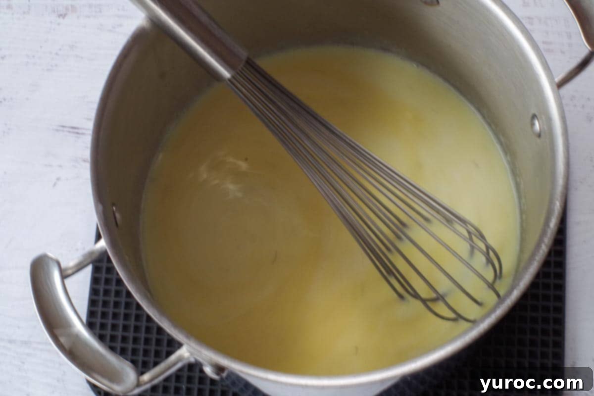 Silky Light Chicken Fettuccine 9 Whisk in a pot with parmesan cheese added, mixing until combined.