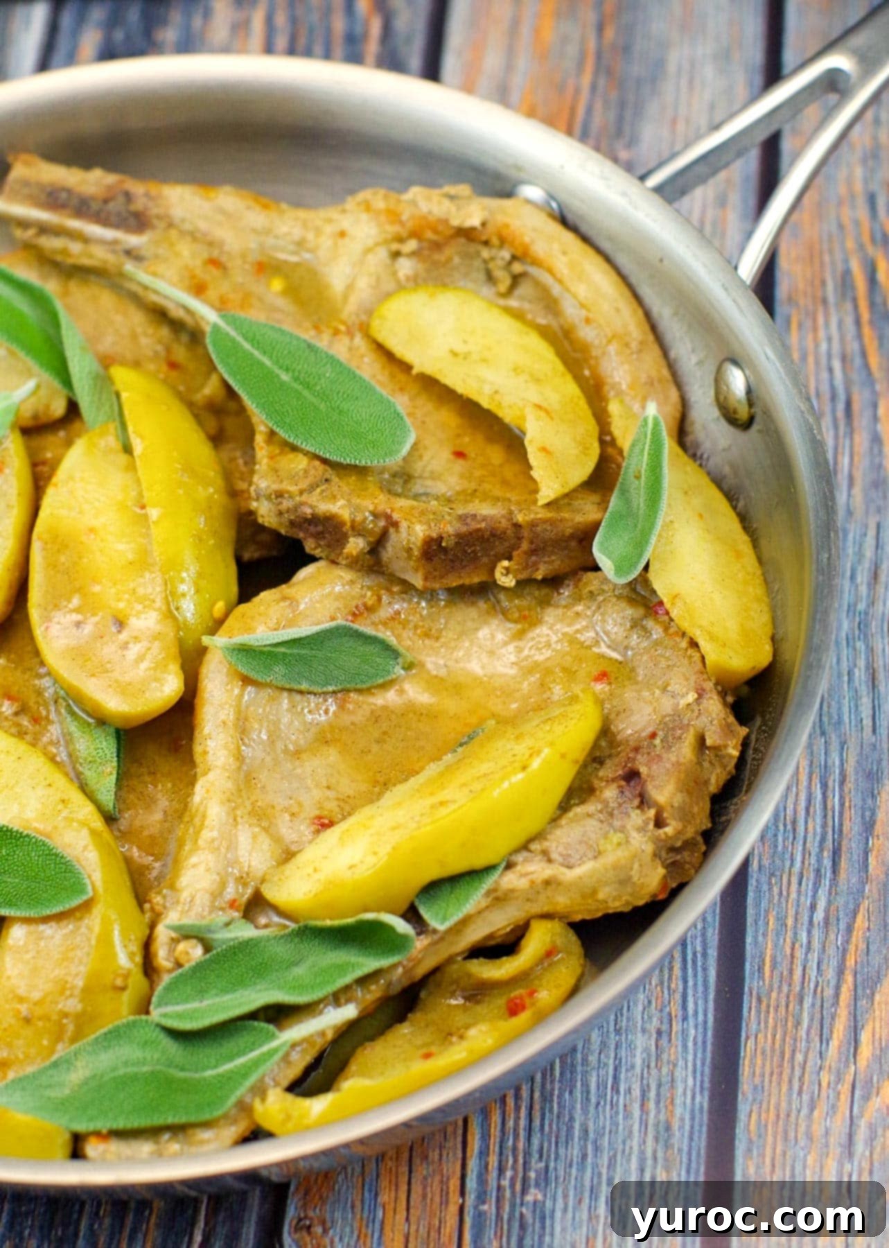 Orchard Herb Pork Chops 3 Half pan of succulent apple and pork chops with vibrant sage leaves, ready to serve
