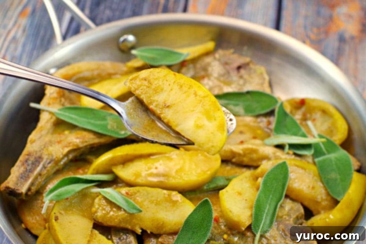Sizzling skillet pork chops with tender apples and aromatic sage in a cast iron skillet, ready to serve
