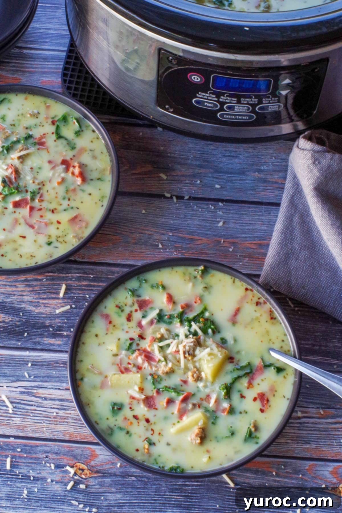 slow cooker zuppa toscana in a black bowl with a slow cooker in the background, showing a large batch
