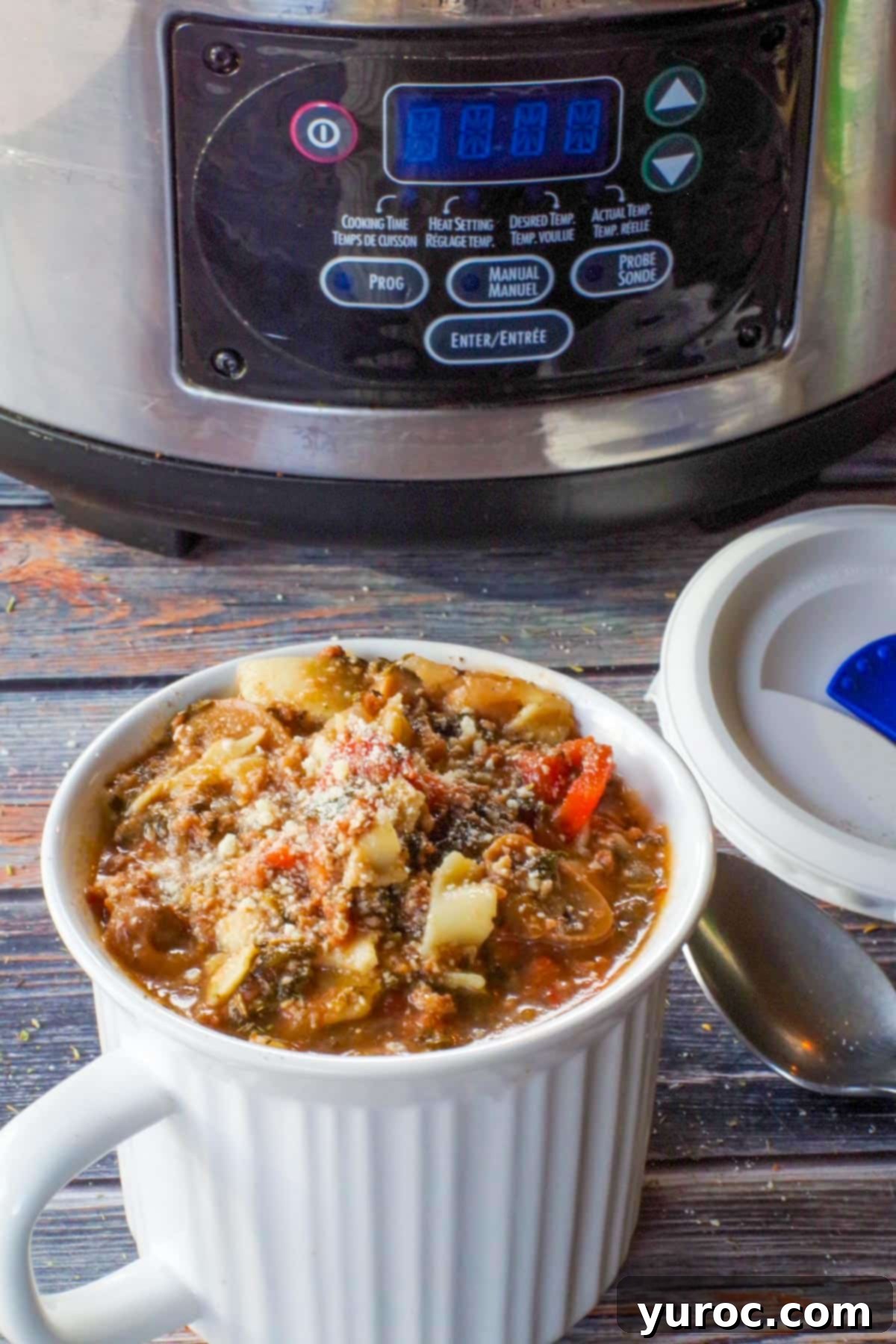 Lasagna soup in a meal mug with a lid, with a slow cooker in the background, perfect for meal prep