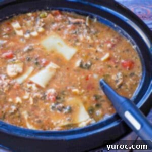 Hearty lasagna soup simmering in a slow cooker, ready to be served with a ladle