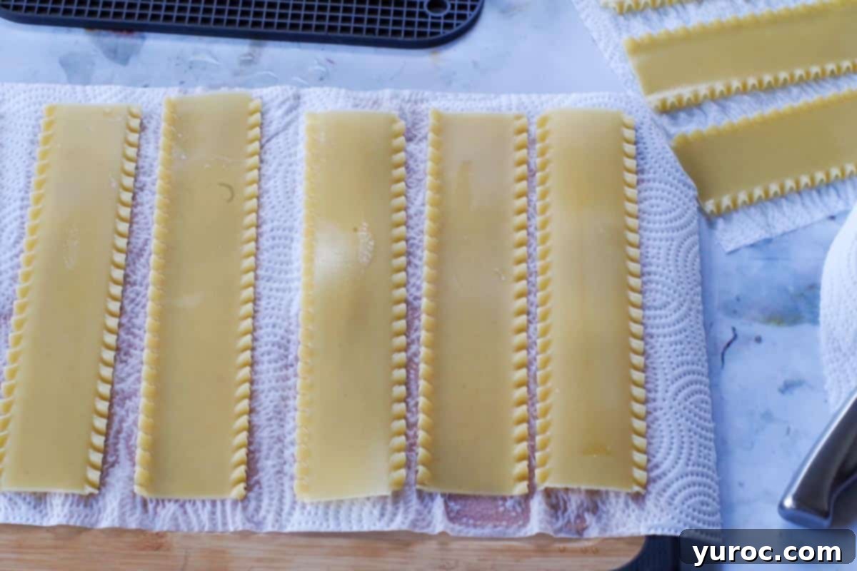 Soaked lasagna noodles laid out on paper towels