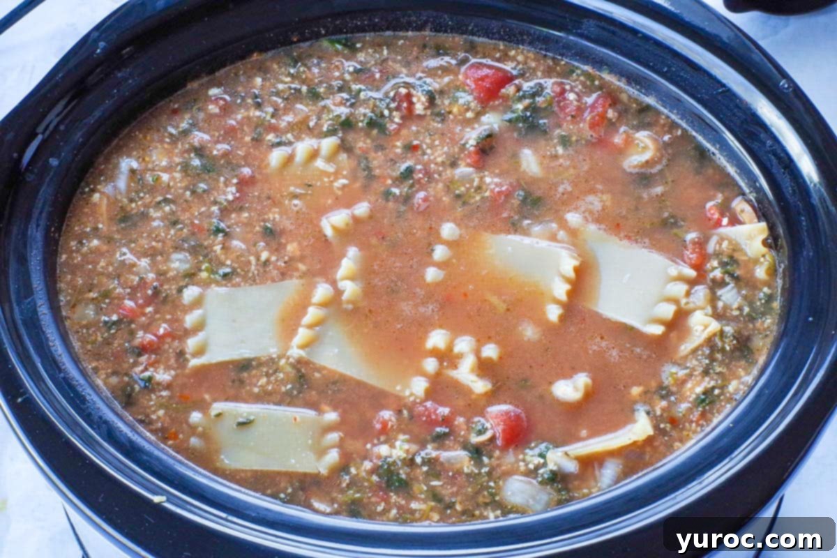 Chopped lasagna noodles added to the simmering slow cooker soup