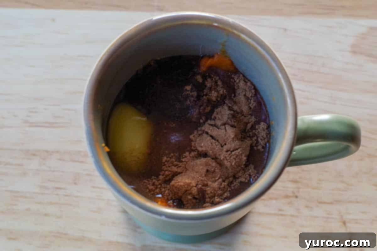 Velvet Pumpkin Mug Bake 4 All ingredients for crustless pumpkin pie added to a microwave-safe mug before mixing.