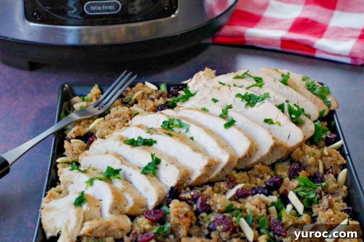 Velvet Pumpkin Mug Bake 9 Sliced slow cooker turkey breast elegantly displayed on a bed of cranberry quinoa dressing on a black platter, with the slow cooker and a red checkered tea towel visible in the background.