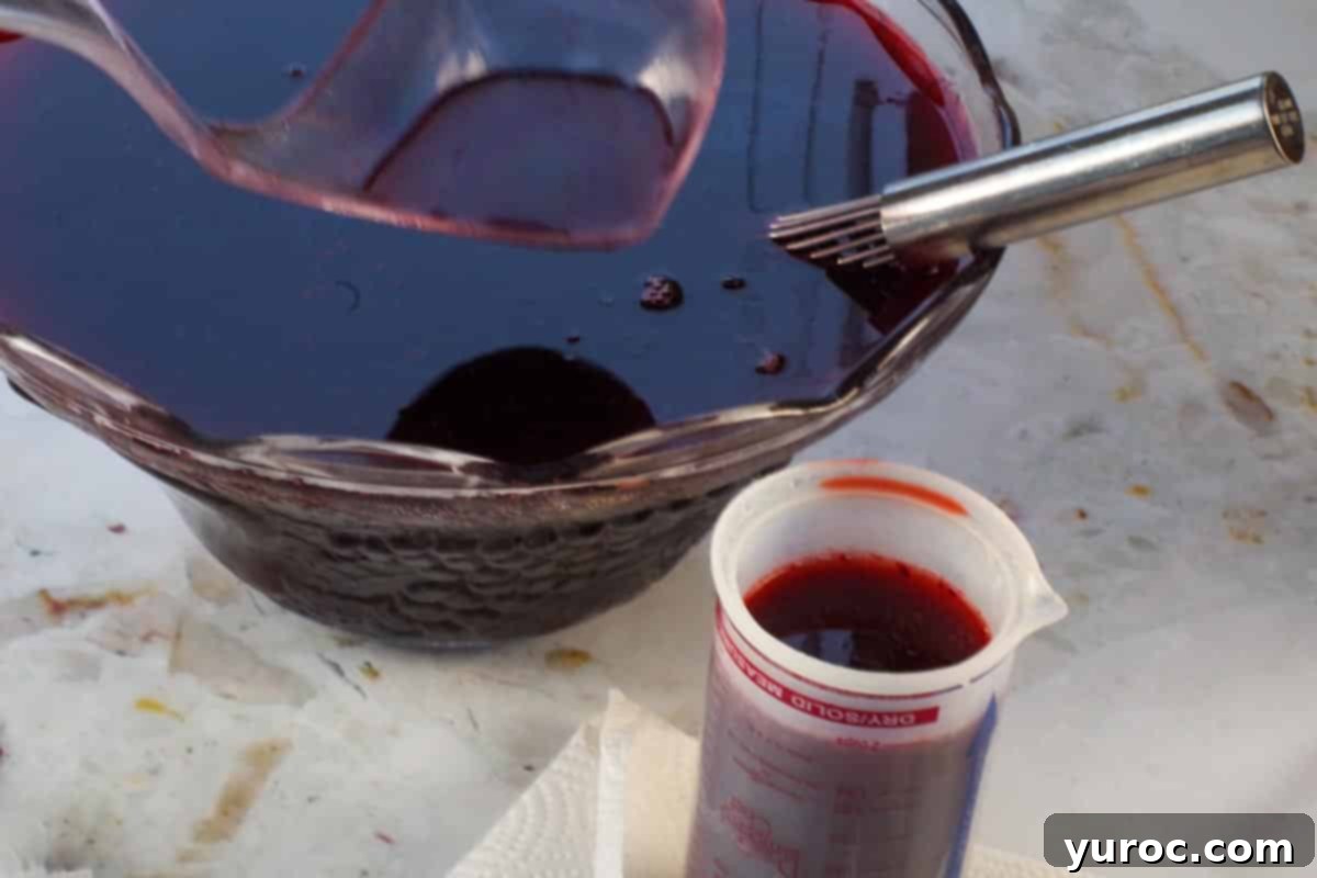 Virgin Blood Bags Halloween 4 Punch being carefully ladled into a liquid measuring cup with a small spout, preparing for blood bag filling.