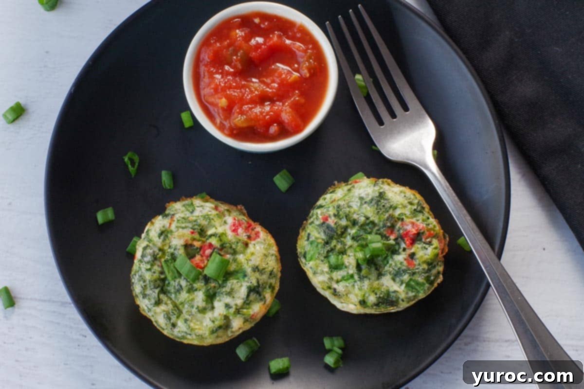 Vibrant Roasted Red Pepper Egg White Bites 2 2 egg white bites on a black plate, with salsa in a small dish and a fork on the plate