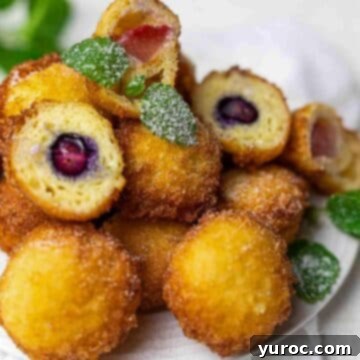 An appetizing display of Fried Mini Cheesecake Bites, showcasing their golden-brown exterior and tempting creamy filling.