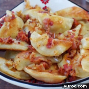 Traditional Ukrainian perogies, generously topped with crispy bacon and sautéed onions, served in a beautiful Ukrainian print dish.