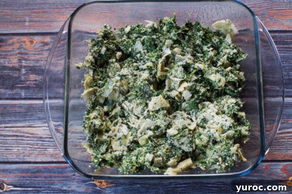 spinach artichoke mixture in glass 8x8 dish