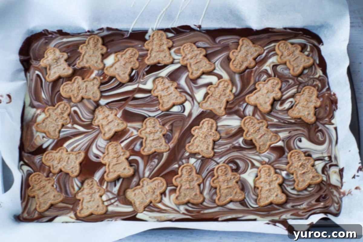 gingerbread man cookies added to marbled chocolate on sheet pan