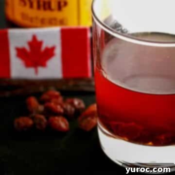 A glass filled with rich butter tart liqueur, artfully positioned with a Canadian flag and scattered raisins in the soft-focus background