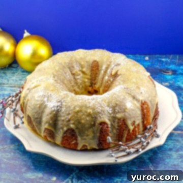 A whole butter tart bundt cake beautifully presented on a white plate, with elegant gold Christmas ornaments gently blurred in the background