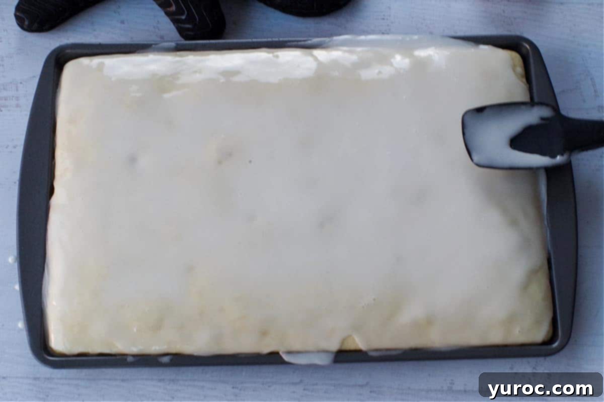 glaze poured over pancakes with spatula spreading it evenly