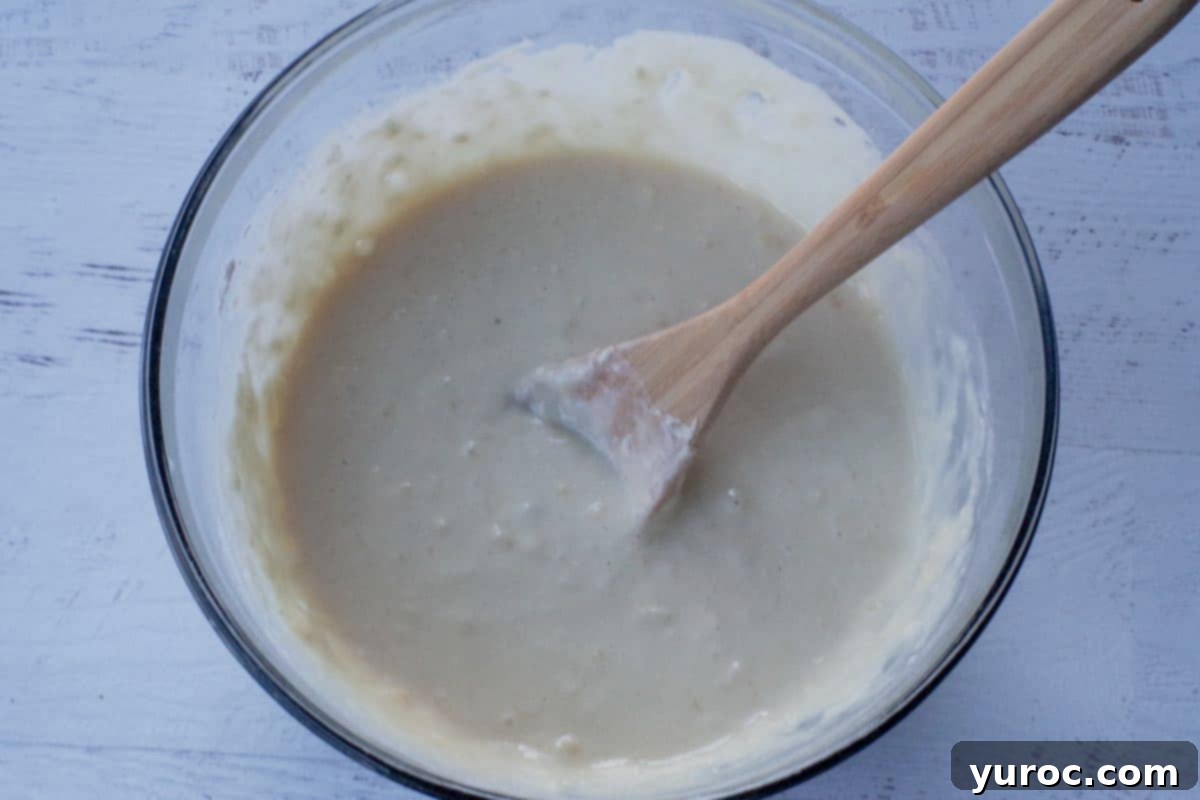 wet and dry ingredients mixed together in large bowl, with wooden spoon