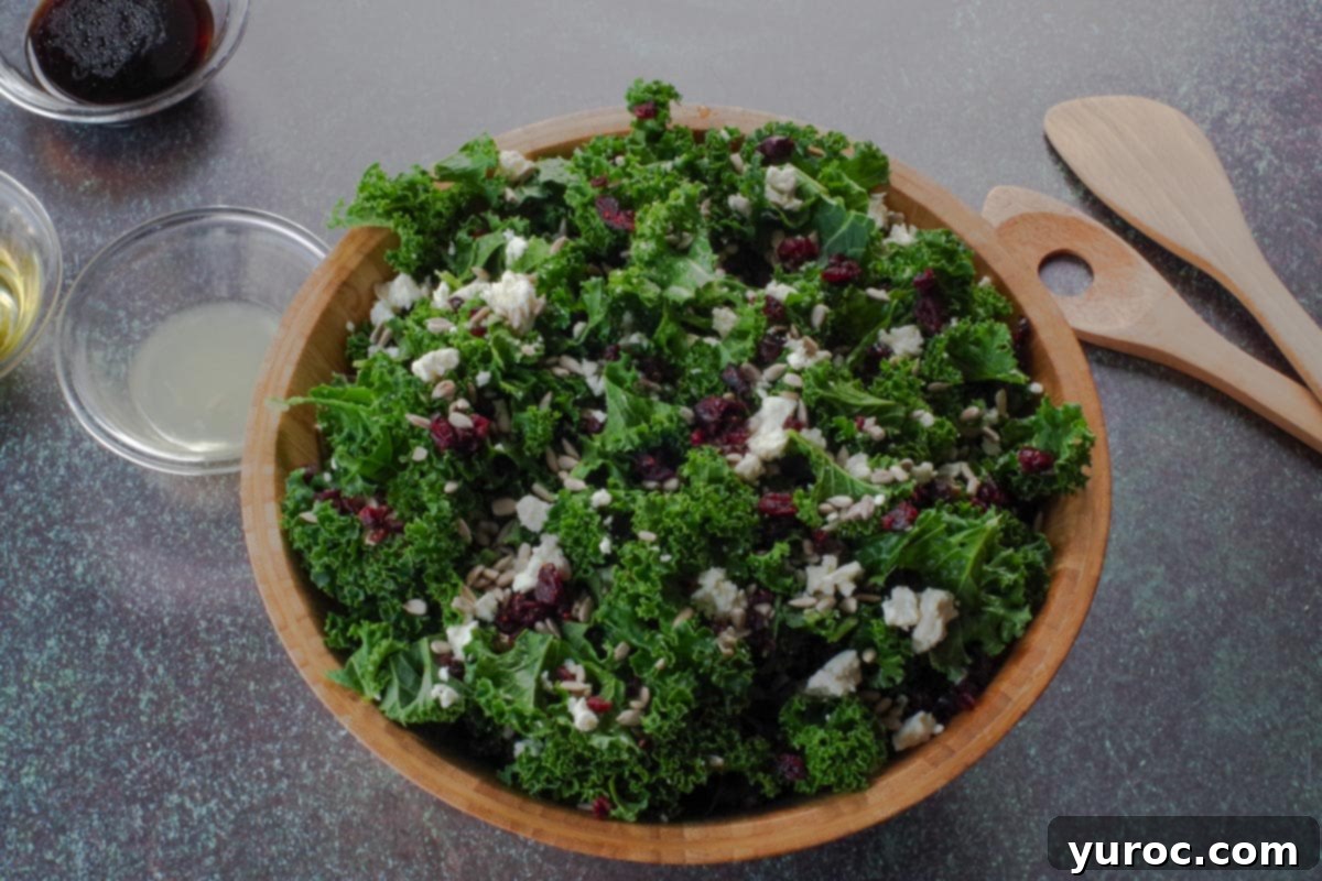 kale, cranberries, feta cheese and sunflower seeds added to a wooden bowl
