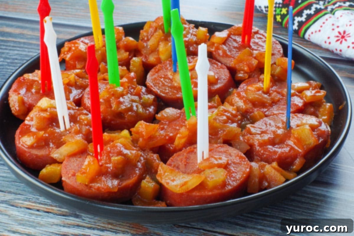 Slow Cooker Kielbasa Bites with colorful plastic skewers, served on a black round plate