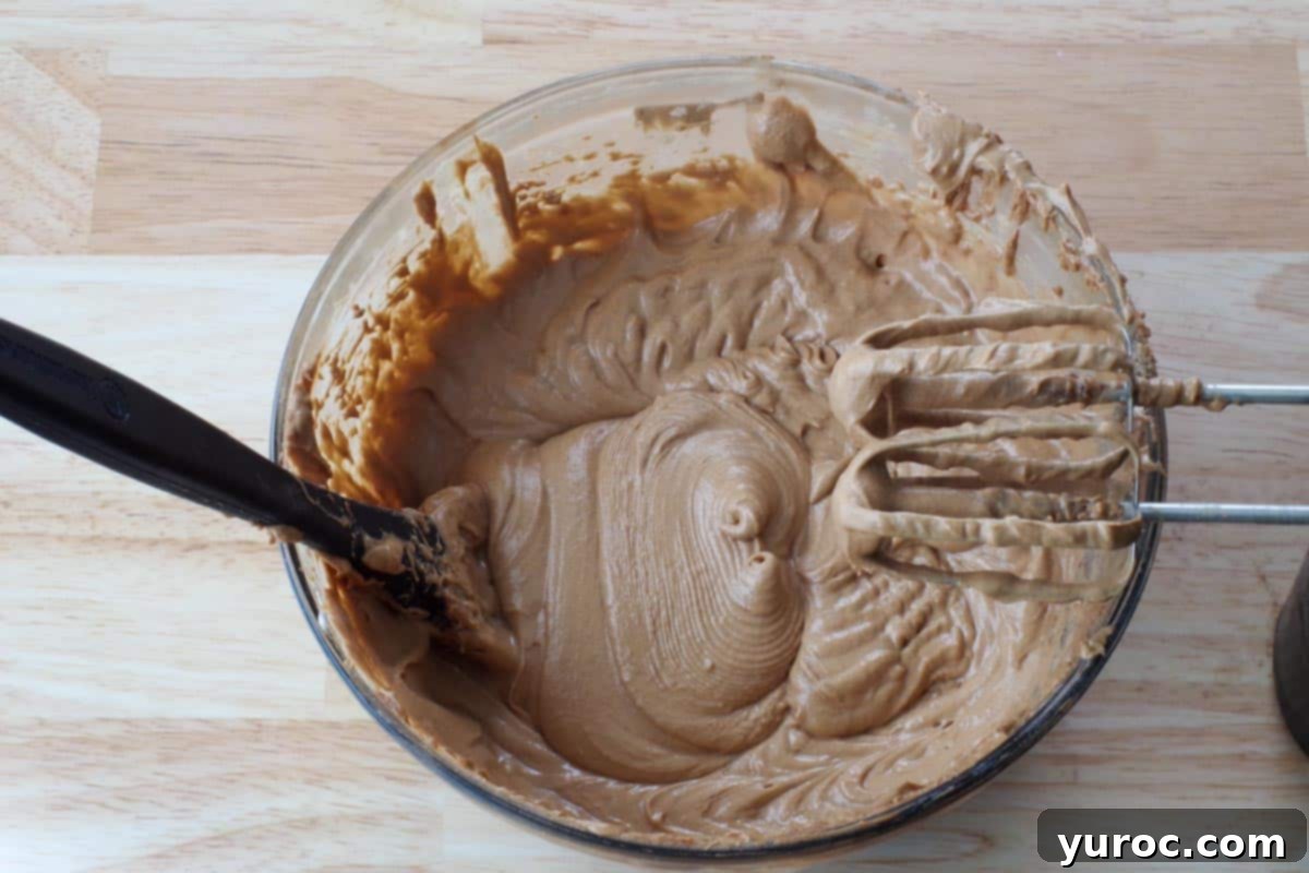 Eggs, sour cream, and vanilla extract being added to the cake batter in a glass bowl.