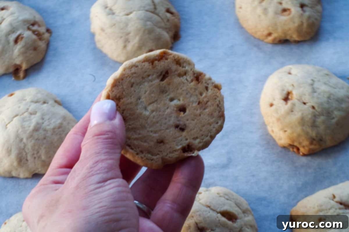 cookie lightly browned on bottom being held up over cookie sheet