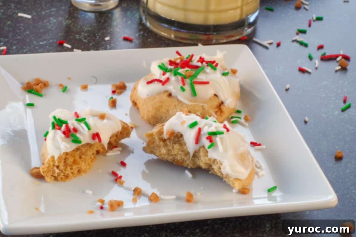 Baileys and eggnog cookie broken in half, with a whole cookie on a white plate