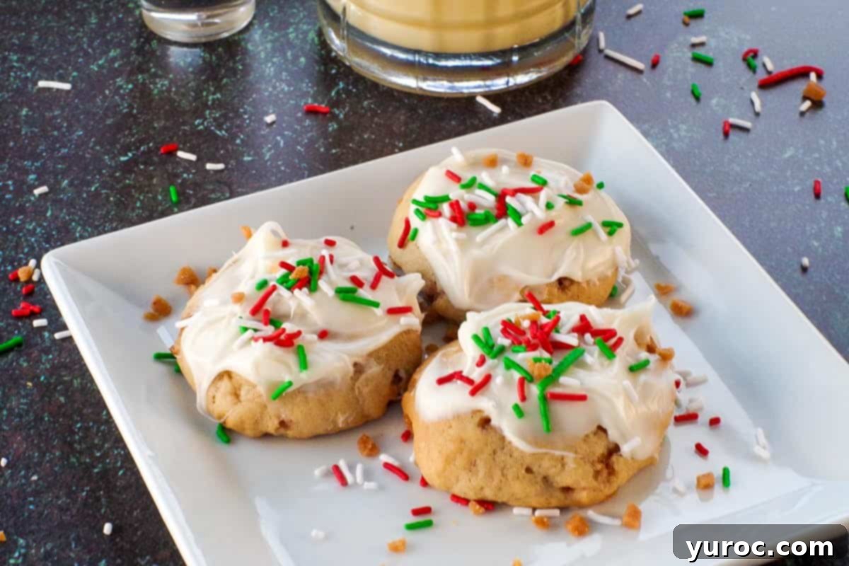 3 eggnog and baileys irish cream cookies on a white plate with a glass of eggnog and a shot of baileys in the background
