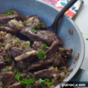 cooked venison steak in a skillet with a spatula turner