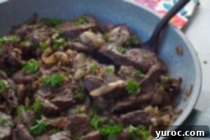 cooked venison steak in a skillet with a spatula turner