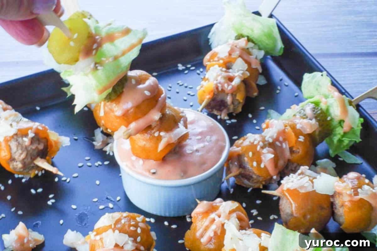 A finished Big Mac Bite on a skewer is being dipped into a small bowl of the special Big Mac sauce, highlighting its deliciousness.