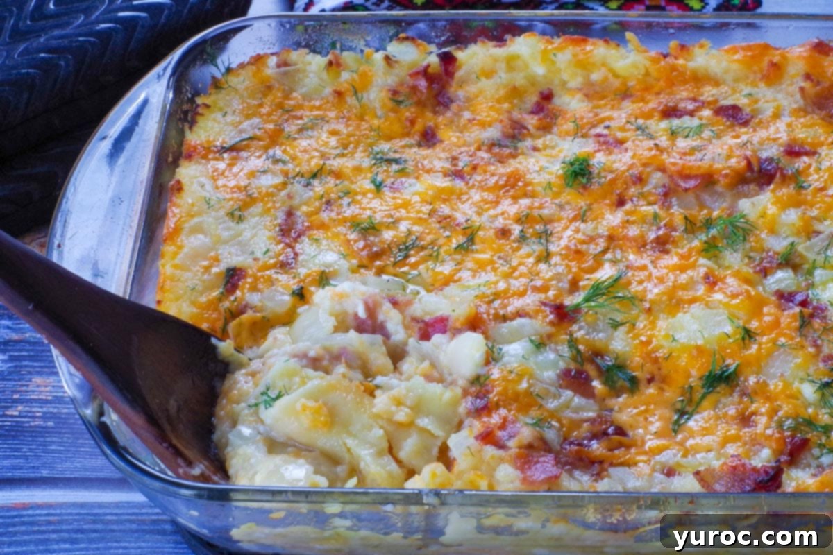 Easy Weeknight Pierogi Casserole 1 lazy pierogi in a glass casserole dish with a dark brown wooden spoon