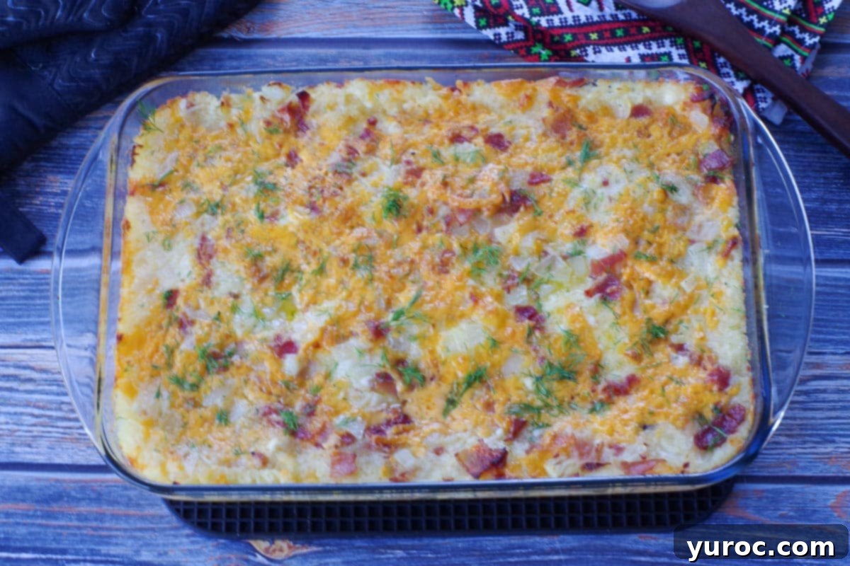 Easy Weeknight Pierogi Casserole 15 baked lazy pierogi casserole, garnished with dill in glass 9x13 pan