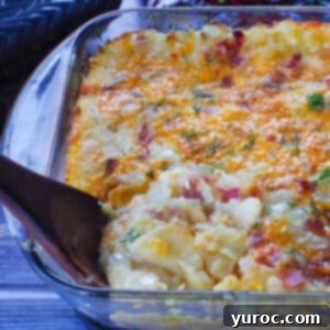 Easy Weeknight Pierogi Casserole 18 lazy pierogi in a glass casserole dish with a dark brown wooden spoon
