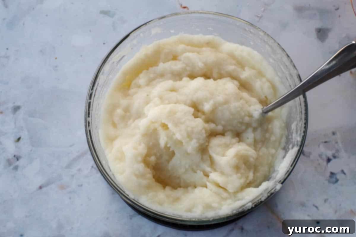 Easy Weeknight Pierogi Casserole 4 instant mashed potatoes being mixed in a glass bowl