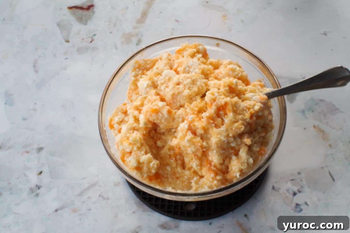 Easy Weeknight Pierogi Casserole 5 cheeses added to instant mashed potatoes in glass bowl