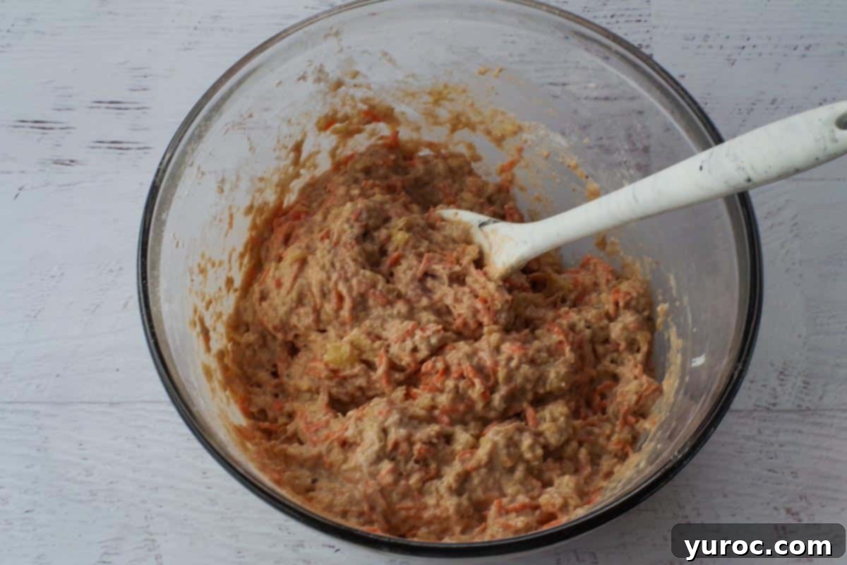 The milk and vinegar mixture, along with chopped walnuts, are added to the pancake batter in a glass bowl, ready for a final gentle stir.