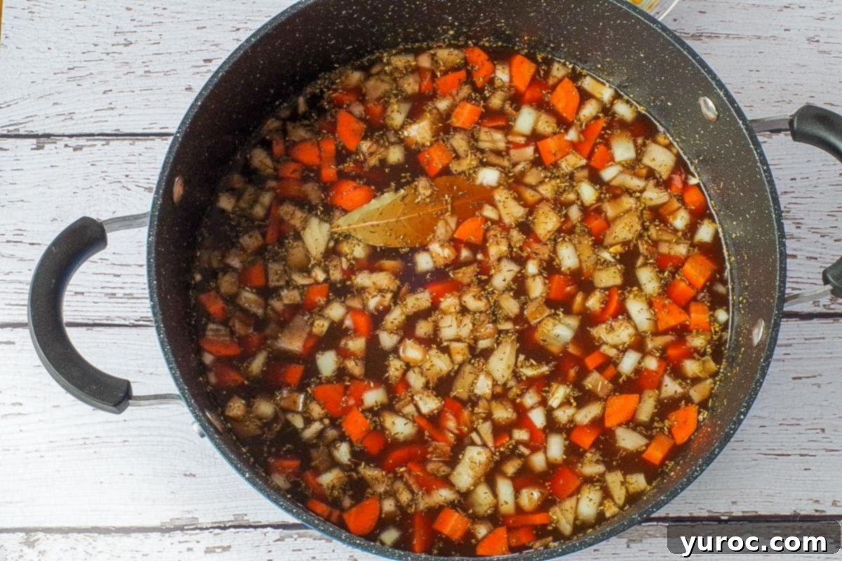 Hearty Ham and Macaroni Soup 4 All essential ingredients for the ham macaroni soup (excluding macaroni, Parmesan cheese, and fresh parsley) are combined in a large soup pot, ready for simmering on the stovetop.
