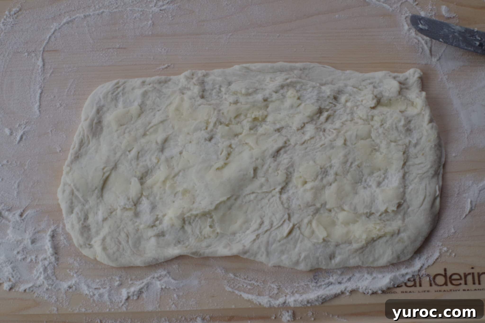 Healthy Cinnamon Swirl Mug Treat 6 butter spread over the dough rectangle on a wooden cutting board